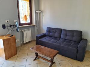 sala de estar con sofá azul y mesa en Betulle 2G, en Leinì