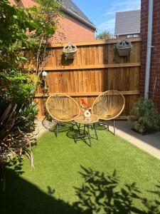 two chairs and a table in a yard with a fence at Chloes Retreat in Norwich