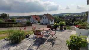 a table and chairs on a patio with a view at Ferienwohnung Naumann in Schotten