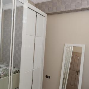 - une chambre avec un placard blanc et un miroir dans l'établissement Apartment Nasr City, au Caire