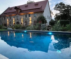 a house with a swimming pool in front of a building at Living in the old granary in Ermsleben