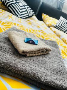 una pila de toallas sentadas encima de una cama en Milan Apartman, en Budapest