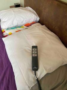 un mando a distancia sentado sobre una cama en Champs Bernard, en Villefranche-de-Rouergue