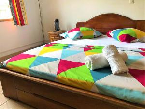 a bed with a colorful comforter and pillows on it at FIIAA in Yaoundé