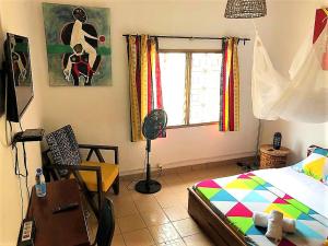 a bedroom with a bed and a desk and a window at FIIAA in Yaoundé
