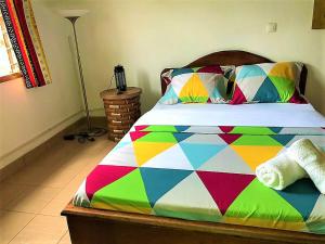 a bed with a colorful comforter in a bedroom at FIIAA in Yaoundé