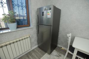 einem Kühlschrank aus Edelstahl in einer Küche neben einem Fenster in der Unterkunft Welcome Inn in Baku