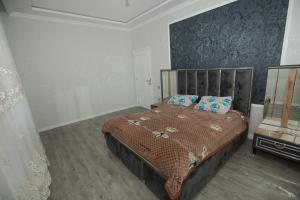 a bedroom with a bed with a brown comforter at Welcome Inn in Baku