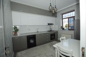 a kitchen with a sink and a washing machine at Welcome Inn in Baku