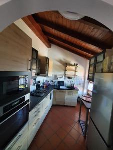 a large kitchen with white cabinets and black appliances at Casa-Shila in Luino