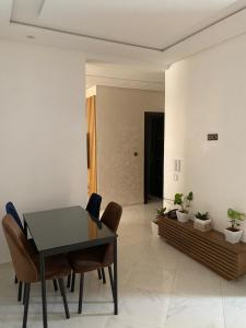 Appartement prestige في القنيطرة: غرفة طعام مع طاولة وكراسي