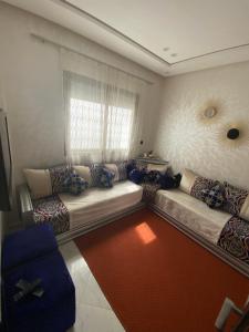 - un salon avec un canapé et une fenêtre dans l'établissement Appartement prestige, à Kenitra