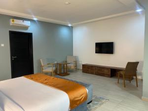 a bedroom with a bed and a table and a tv at Breezes Beach Resort 