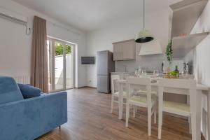 een witte keuken met een tafel en een blauwe bank bij Casa di Rosa by BarbarHouse in Maglie