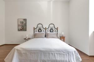 um quarto branco com uma grande cama branca e 2 almofadas em Casa di Rosa by BarbarHouse em Maglie