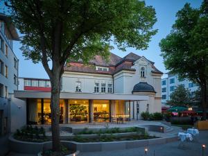 a building with a tree in front of it at Asam Hotel in Straubing