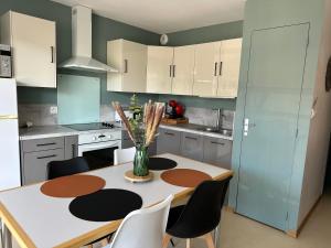 a kitchen with a table with a vase of flowers on it at Studio cabine vue mer latérale in Sainte-Cécile-Plage