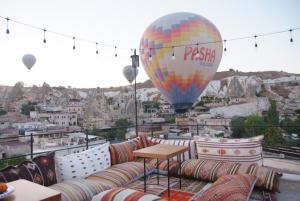 a hot air balloon flying over a city with couches at Peruna Cave in Goreme