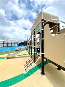 a playground with a slide and a pool at Cozy Holiday Home at Batulao Artscapes 2Br brand new fully airconditioned in Calo
