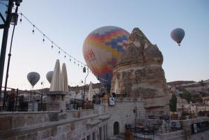 un grupo de globos de aire caliente volando sobre una ciudad en Peruna Cave, en Göreme