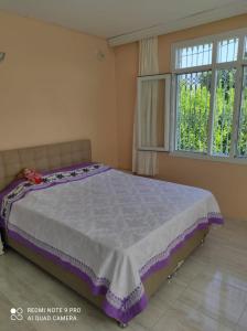 uma cama num quarto com uma grande janela em Ferienhaus Domizil em Tarsus