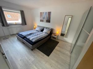 - une chambre avec un lit et un grand miroir dans l'établissement Haus Weitblick Alva, à Flensbourg