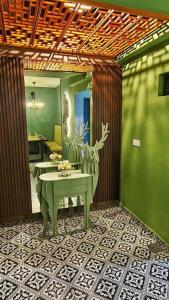 a room with a green wall and a table with a chair at Rusa Cottage (Sleeps 10 pax - 1 min walk from KSL) in Johor Bahru