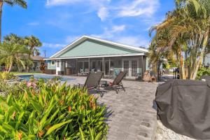 a house with two chairs and a swimming pool at Awesome Location with Dock, Pool, Bicycles & Kayaks in Cape Coral