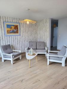 Sala de estar con 3 sofás y mesa de centro en Gîte Cadet rousselle, en Lessay