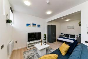 a living room with a blue couch and a bed at Beautiful and Spacious 1 Bed Apartment in London