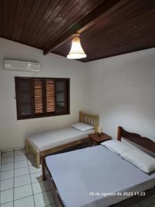 1 dormitorio con 2 camas y ventana en Casa em Ilhabela, en Ilhabela