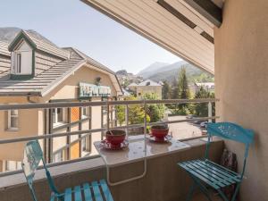 2 sillas y mesa en un balcón con vistas en Appartement Briançon, 2 pièces, 4 personnes - FR-1-330C-19 en Briançon