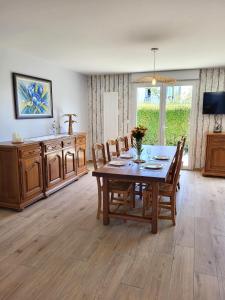 a dining room with a wooden table and chairs at Gîte Cadet rousselle in Lessay