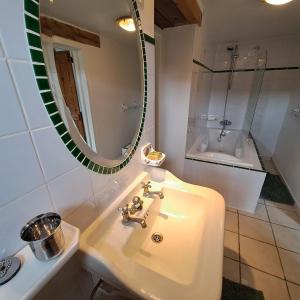 La salle de bains est pourvue d'un lavabo, d'un miroir et d'une baignoire. dans l'établissement Chambres d hotes proche Macon, à Grièges
