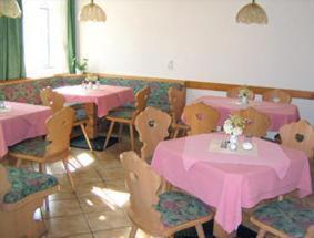 ツヴィッカウにあるHotel Haus Marienthalのピンクのテーブルと椅子が備わるレストラン
