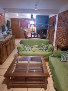 uma sala de estar com um sofá verde e uma mesa de centro em CABAÑAS LOS OLIVOS em Las Grutas