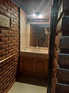 a bathroom with a sink and a brick wall at CABAÑAS LOS OLIVOS in Las Grutas +30 photos
