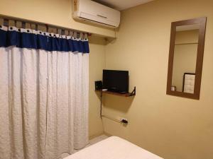 a bedroom with a bed and a mirror and a window at San Lorenzo 3314 2piso ascensor in Rosario