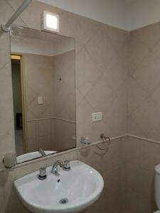 uma casa de banho com um lavatório e um espelho em San Lorenzo 3314 2piso ascensor em Rosário