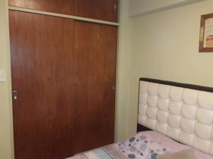 Un dormitorio con una gran puerta de madera y una cama en San Lorenzo 3314 2piso ascensor en Rosario