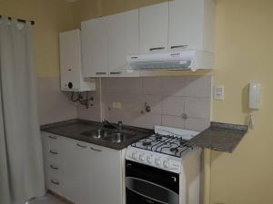 a small kitchen with a stove and a sink at San Lorenzo 3314 2piso ascensor in Rosario