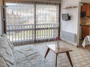 - un salon avec un canapé, une table et une fenêtre dans l'établissement Appartement Briançon, 1 pièce, 2 personnes - FR-1-330C-42, à Briançon