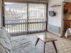 ein Wohnzimmer mit einer Couch und einem Tisch und einem Fenster in der Unterkunft Studio cosy 2/3 pers au cœur de Briançon, proche centre-ville et télécabine - FR-1-330C-42 in Briançon