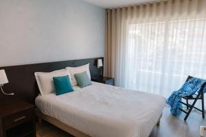 a bedroom with a large bed and a window at Résidence Châteauneuf in Menton +140 photos