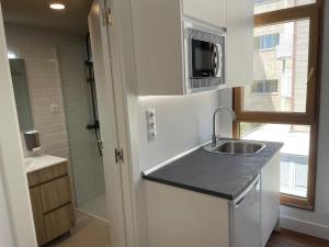 a small kitchen with a sink and a shower at C9 Magnífico apartamento en zona tranquila in Madrid