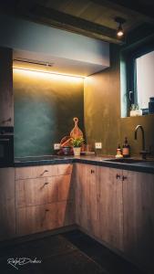eine Küche mit einer Theke mit einem Waschbecken und einem Fenster in der Unterkunft Het Ovenhuisje in Denderwindeke