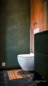 Denderwindeke的住宿－Het Ovenhuisje，浴室设有白色浴缸和绿色墙壁。