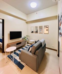 a living room with a couch and a flat screen tv at 4 Majestic View in Iloilo City