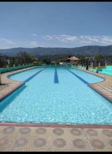 a large swimming pool with blue water at CABAÑA 5-1 CONDOMINIO LOS SAUCES MONIQUIRA in Moniquirá