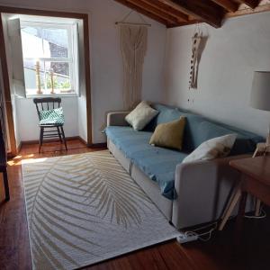 - un salon avec un canapé bleu et une fenêtre dans l'établissement Graciosa Family House, à Santa Cruz da Graciosa